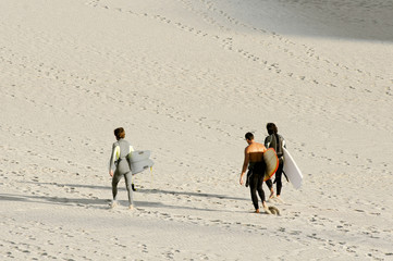 Fototapeta na wymiar surfers on seashore at sunshine in Sabon beach Galicia