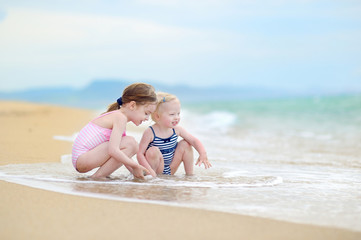 Two little sisters having fun on a beach © MNStudio