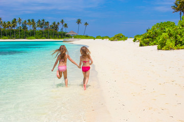 Obraz na płótnie Canvas Adorable little girls having fun during beach vacation