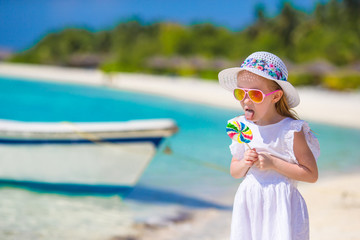 Adorable little girl with lollipop on tropical beach