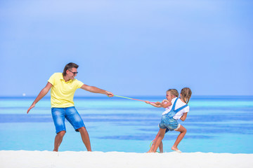 Young father and little girls have fun together during tropical