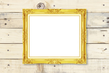 Antique gold frame on wooden wall ;. Empty picture frame on whit