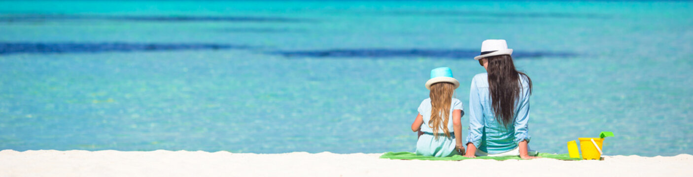 Little Girl And Young Mom Relaxing At Beach