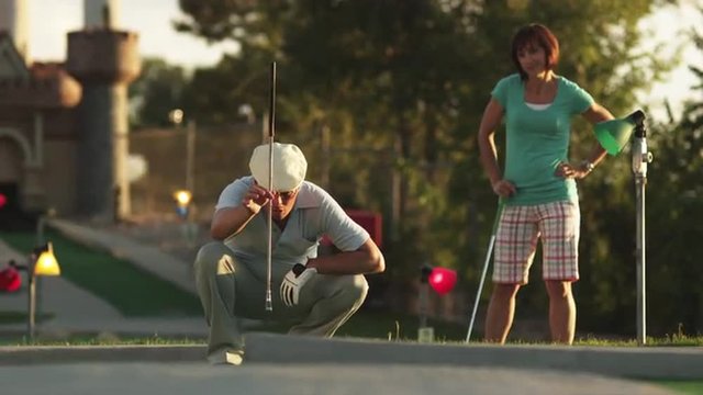 MS Man playing mini golf, suddenly running around waving hands, Orem, Utah, USA