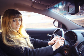 Obraz na płótnie Canvas portrait of a girl in a car driver at the wheel