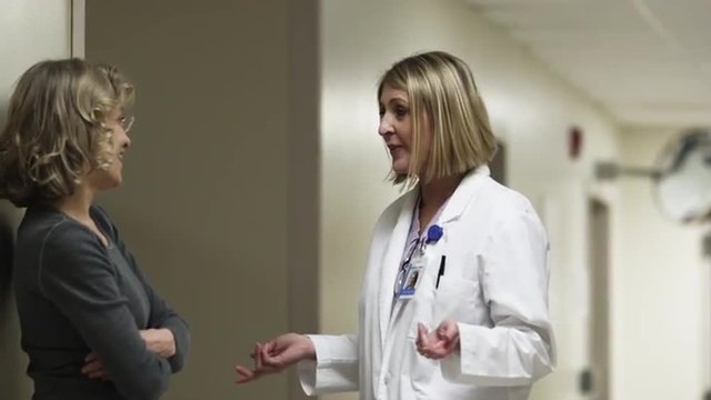 MS Doctor and friend talking in hospital corridor / Payson, Utah, USA