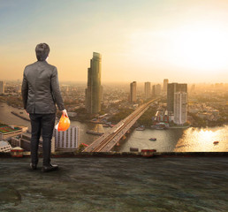 engineering man standing on top of building looking to urban sce