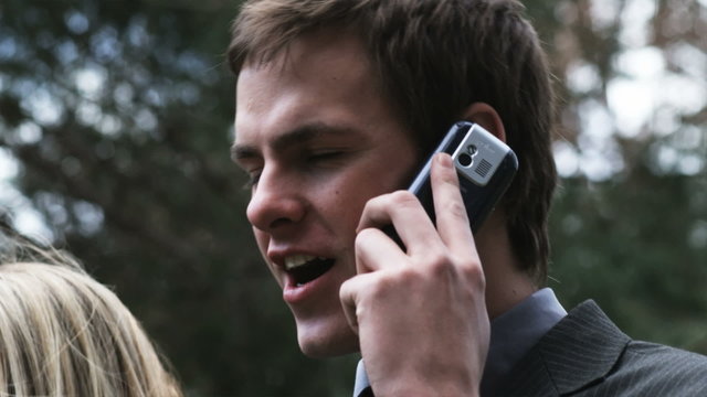 man talking on his cell phone at a funeral