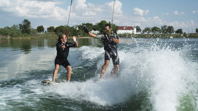two people wakeboarding behind a boat
