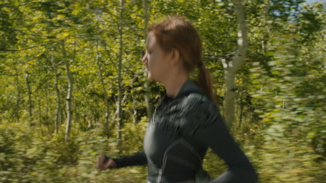 Slow motion shot of young woman running through forest / American Fork Canyon, Utah, United States