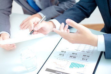 Two businessmen looking at report and having a discussion in off