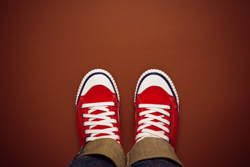 Feet From Above, Teenager in Sneakers Standing on Brown Backgrou