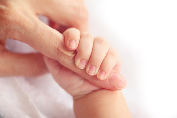 Obraz na płótnie Canvas Newborn baby holding mother's hand, image with shallow depth of