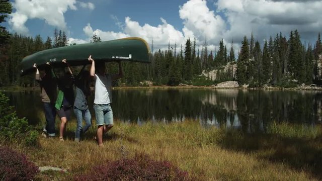 MS Four people carrying kayak along water's edge, Uinta Mountains, Utah, USA