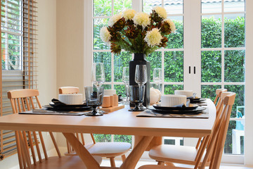 wooden table and chairs in dining room with elegant table settin