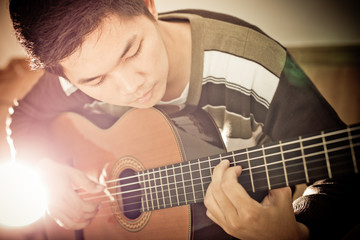 Fototapeta premium Practicing in playing guitar. Handsome young men playing guitar