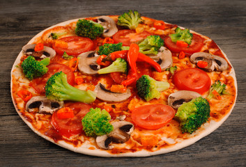 Vegetarian pizza on a wooden table.