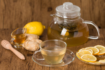 Cup of ginger tea with honey and lemon on wooden table