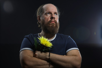 bearded brutal man with a flower