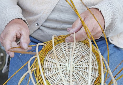 laborious hands of elder craftsmen create a wicker basket