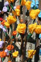 colorful roses made of paper hanging from the rusty gate