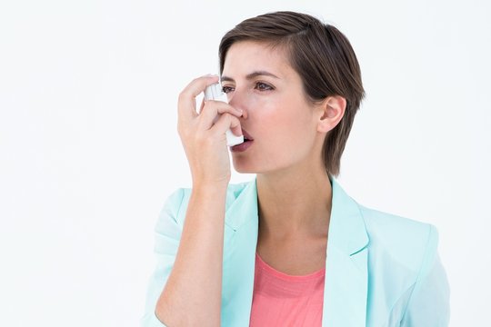 Pretty woman using her inhaler