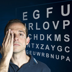 Naklejka premium Hombre leyendo letras del oculista