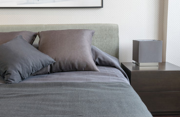 bedroom interior with grey pillows on bed and decorative table l