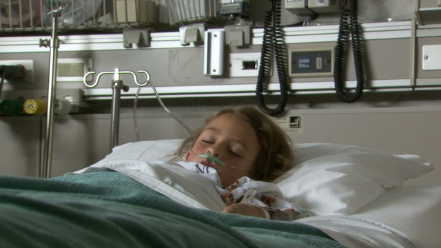 Child with respirator in hospital bed sleeping