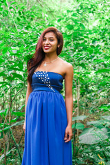 beautiful latin woman with blue dress at forest