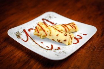 Delicious pancakes with meat, spices and sauce on a white plate