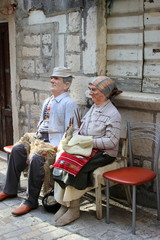Altes Ehepaar (Puppen) auf einer Parkbank in einer Altstadt