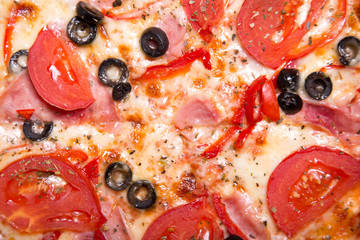 Texture of tasty Italian pizza with ham, tomatoes and olives