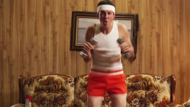 MS TU Geek man exercising with dumbbells in living room, Orem, Utah, USA
