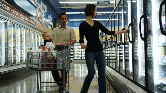 couple with a baby grocery shopping