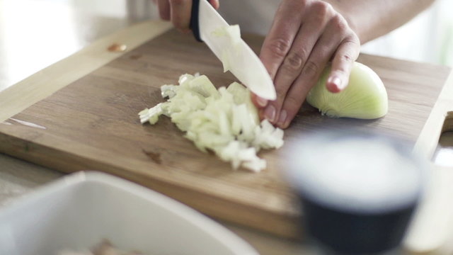 Woman slicing onion  in kitchen, slow motion shot at 240fps
