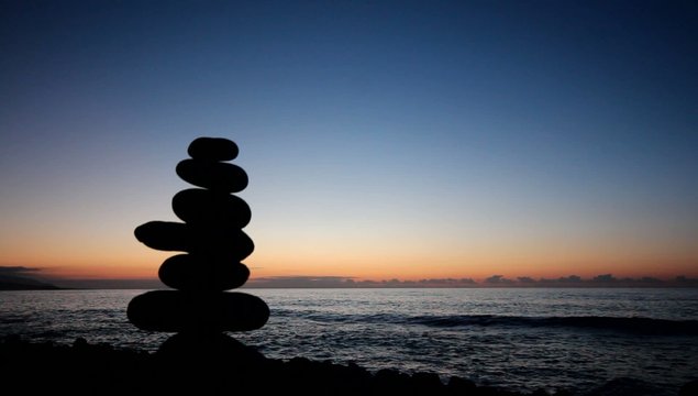 Sunset at ocean / beach with stacked stones silhouette