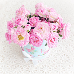 Beautiful fresh pink roses on a light background .