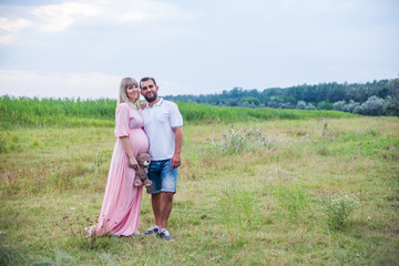 man and pregnant woman on nature