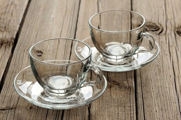 Two empty glass teacups on wooden background