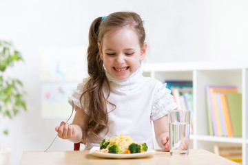 joyful child eating healthy food at home