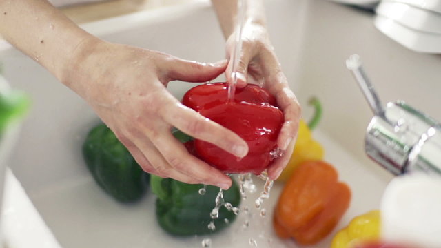 Woman washing red pepper under tap water, slow motion  240fps

