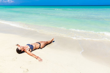 Fototapeta na wymiar Girl lying on caribbean beach
