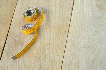 twisted tape measure on wood background