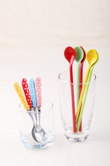 colorful spoon and polka dot fork in clear glass