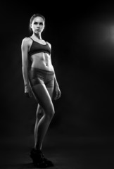 Portrait of sporty young woman with muscular body looking at cam