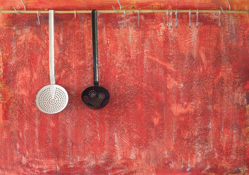 old cooking utensils against rustic red wall; free copy space