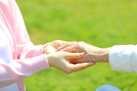 シニア男性の手を取る・新緑