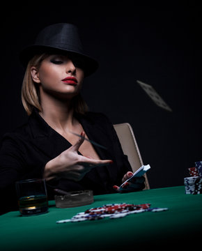 Beautiful young woman playing poker isolated on black background.