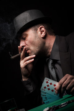 Male gambler playing poker isolated on black background.